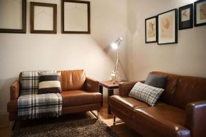 a living room with two brown leather couches and a table at Circa Ruby Mint Daylesford in Daylesford +1 photo