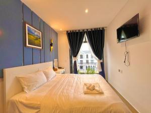 a bedroom with a bed with a towel on it at BISTRO HOTEL Grand World Phú Quốc in Phu Quoc