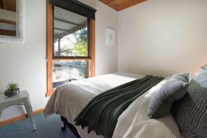 a bedroom with a bed and a window at The Lodge Daylesford in Hepburn