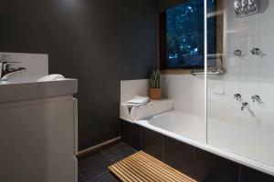 a bathroom with a shower and a tub and a sink at The Lodge Daylesford in Hepburn