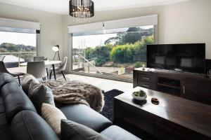 a living room with a couch and a flat screen tv at Amelia Daylesford in Daylesford