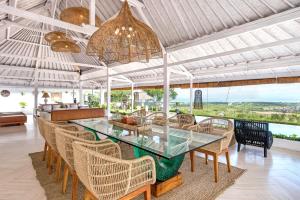 a dining room with a glass table and chairs at Villa Puri Balangan in Uluwatu