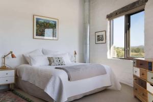 um quarto branco com uma cama e uma janela em Lithia Guest House - Daylesford Region em Hepburn Springs