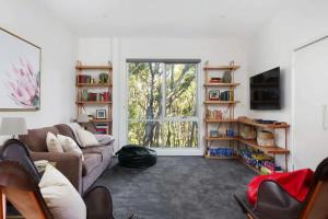 sala de estar con sofá y ventana en The Bird House - Hepburn Springs Daylesford, en Hepburn Springs