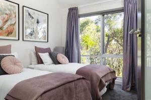 two beds in a room with a window at The Bird House - Hepburn Springs Daylesford in Hepburn Springs