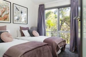 two beds in a room with a window at The Bird House - Hepburn Springs Daylesford in Hepburn Springs