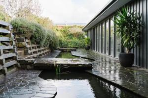 un estanque koi en un jardín junto a un edificio en Cousin Gilbert Daylesford, en Daylesford