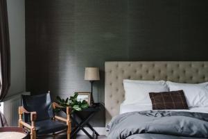 1 dormitorio con una pared verde, 1 cama y 1 silla en Cousin Gilbert Daylesford, en Daylesford