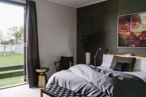 a bedroom with a bed and a large window at Cousin Gilbert Daylesford in Daylesford