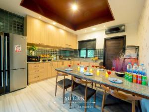 a kitchen with a table with chairs and a refrigerator at Milan Private Pool Villa Huahin in Hua Hin
