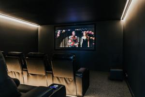 a cinema room with chairs and a flat screen tv at The Deck - Hepburn Springs Daylesford in Hepburn