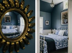 a bedroom with blue walls and a mirror at Candlebark Daylesford in Daylesford