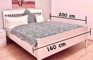 ein Schlafzimmer mit einem großen weißen Bett mit zwei Uhren darauf in der Unterkunft Gästehaus Backes in Eppelborn