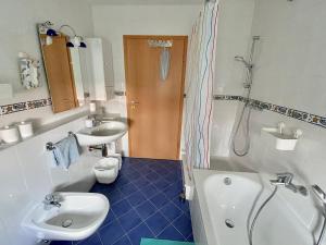 ein Badezimmer mit einer Badewanne, einem Waschbecken und einem WC in der Unterkunft Gästehaus Backes in Eppelborn