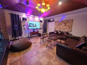 a living room with leather couches and a tv at Milan Private Pool Villa Huahin in Hua Hin