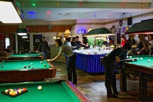 a group of people playing pool in a restaurant at NB Hotel with Free Parking in Riga
