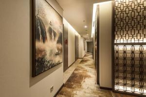 a hallway with paintings on the walls and a hallway with a hallwayngth at Ashley Tang Menteng Jakarta in Jakarta