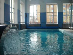 een zwembad met een fontein in een gebouw bij Hotel Olympia in Saransk
