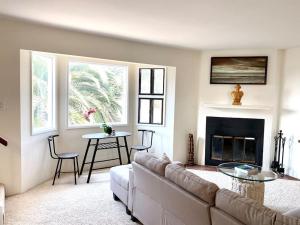 sala de estar con sofá y chimenea en Modern & Cozy Gem ~ Walk to the Beach ~ Queen Beds, en Carpinteria