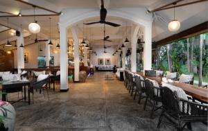 un restaurante con sillas y mesas y un bar en The Urban, en Siem Reap