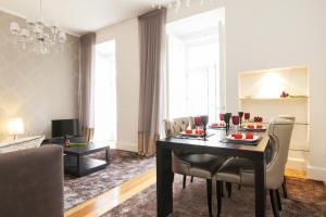 - un salon avec une table à manger et des chaises dans l'établissement JOIVY Downtown Blue Apartments, à Lisbonne