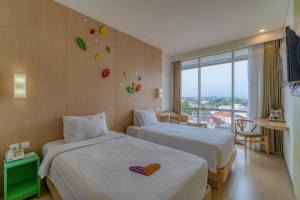 Postel nebo postele na pokoji v ubytování Ascent Hotel & Cafe Malang