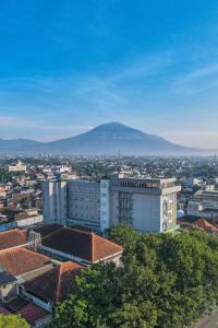 uitzicht op een stad met een berg op de achtergrond bij Ascent Hotel & Cafe Malang in Malang