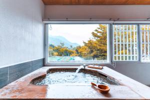 uma casa de banho com uma banheira e uma janela em CDR Hotspring Resort em Liugui