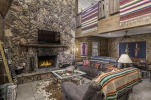 a living room with a stone wall with a fireplace at Stay Happy in Ruidoso