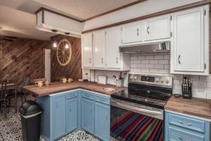 a kitchen with blue cabinets and a stove top oven at Stay Happy in Ruidoso