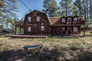a large wooden house in the middle of a field at Stay Happy in Ruidoso