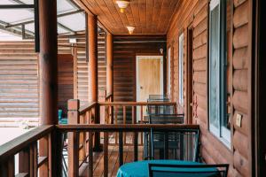 a porch of a cabin with chairs and a door at CDR Hotspring Resort in Liugui