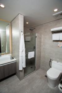 a bathroom with a shower and a toilet and a sink at UNWND Flats in Manila