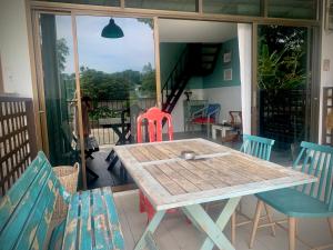 een houten tafel en stoelen op een veranda met een tafel en stoelen bij Island House Rentals 40 in Ko Samed