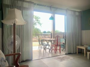 een woonkamer met een vloerlamp en een tafel en stoelen bij Island House Rentals 40 in Ko Samed