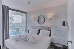 Un dormitorio con una cama blanca con toallas. en Wave Międzyzdroje Resort & SPA - Sea&Forest View B644 en Międzyzdroje
