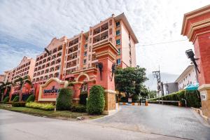 a large pink building on the side of a street at SEVEN SEAS CONDO RESORT in Jomtien Beach