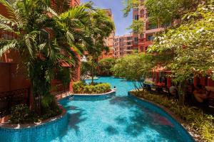 a swimming pool in a resort with palm trees and buildings at SEVEN SEAS CONDO RESORT in Jomtien Beach