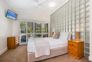 a bedroom with a large bed and a tv on a wall at Mirra Chana in Mooloolaba