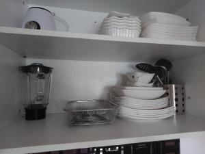 ein Küchenregal mit Tellern, Schalen und Geschirr in der Unterkunft 3 bed 3 bath Friendly, Friendship area, Fibre bdb in Angeles