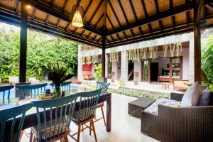 an outdoor patio with a table and chairs at Pukakoo Villas and Suite by Supala in Ubud