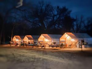 a row of lodges at night with lights on at Son's Rio Cibolo Glamping Cabin #G Brand New Creek-front Cabins with SO Many Amenities! in Marion