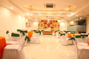a banquet hall with white and green chairs at Hotel Darbar-E-Khas A member of Crimson Hotels in Bareilly