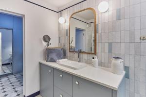ein Bad mit einem Waschbecken und einem Spiegel in der Unterkunft Sofia Balticus Check-in in Misdroy