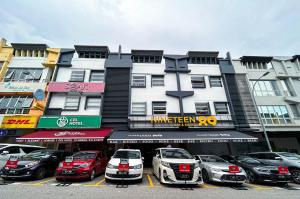 a parking lot with cars parked in front of a building at Cel Hotel in Skudai