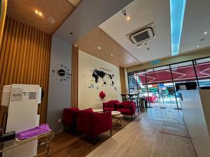 a restaurant with red chairs and a table in a room at Cel Hotel in Skudai