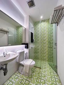 a bathroom with a shower and a toilet and a sink at Cel Hotel in Skudai