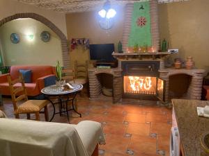sala de estar con chimenea y TV en Apartamentos La Granja en Hinojares