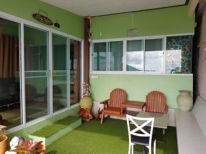 a room with two chairs and a table on a porch at Mhork Buri Resort in Khao Kho