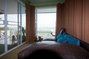 a bedroom with a bed and a large window at Mhork Buri Resort in Khao Kho